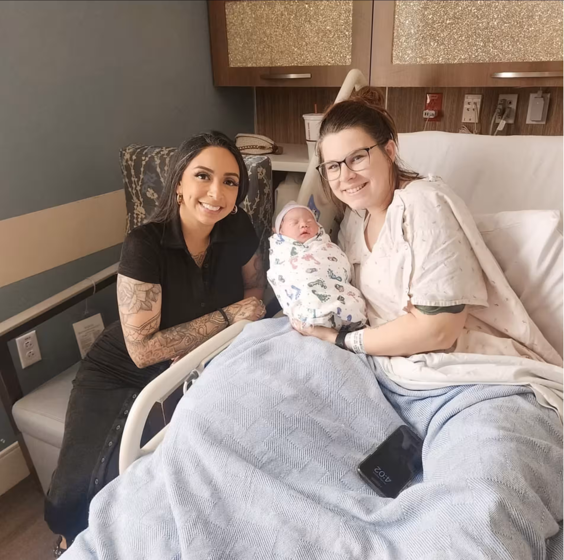 A Patriot Conceptions surrogate and intended parent with their newborn in the hospital on delivery day