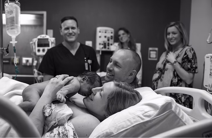 Intended parents meeting their newborn in a hospital after a family-building journey.