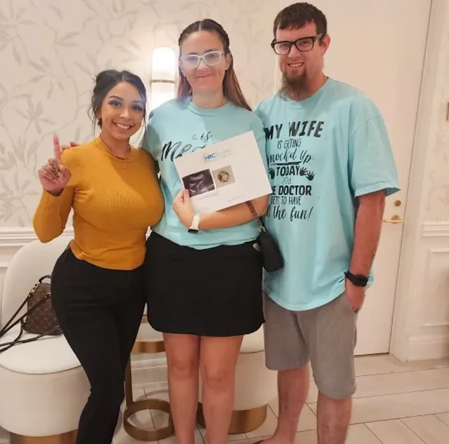 Compassionate surrogate holding hands with intended parents