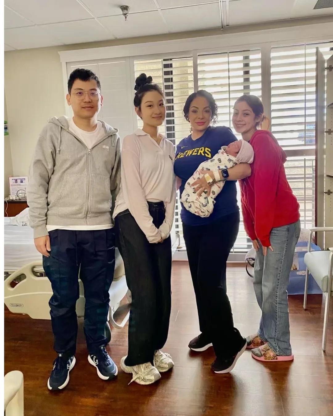 Intended parents, their surrogate, and their newborn together after delivery.